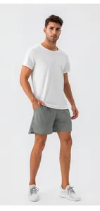 Completo sportivo estivo uomo con t-shirt bianca traspirante e pantaloncini da corsa grigi
