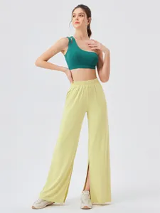 Women's yoga set featuring light green one-shoulder bra and pale yellow split-leg wide pants