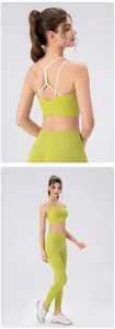 Detail view of avocado green sports bra with white cross-back straps and matching yoga pants
