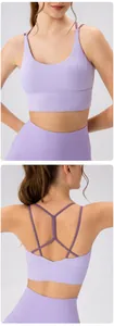Detail showing cross-back straps on purple sports bra and high-waist yoga leggings