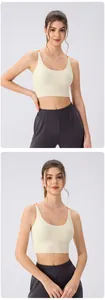 Detailed close-up of cream sports bra with orange straps and high-waist grey gym leggings
