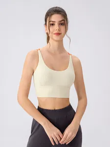 Women's cream sports bra with contrast orange straps and grey high-waist joggers set