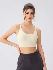 Women's beige sports bra with orange straps and grey leggings set for yoga and fitness