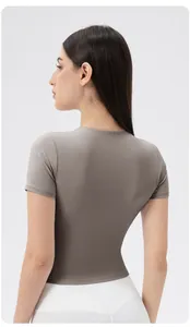 Rear view of taupe slim-fit short sleeve yoga top with back seam detail and elastic fabric
