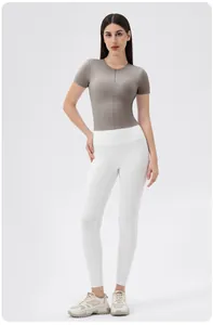 Detail of grey short sleeve yoga top with half-zip design and high waist white leggings
