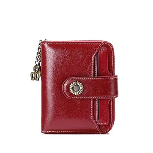 Dark red oil wax leather wallet with daisy buckle and clover pendant on white background