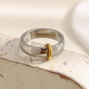 Minimalist silver and gold interlocking stainless steel band ring with polished finish