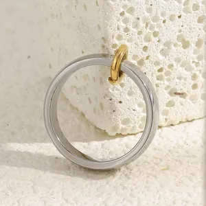 Macro shot of minimalist silver stainless steel ring with a small gold loop accent
