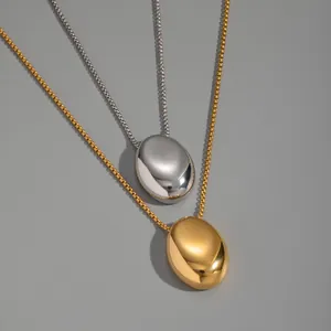 Détail de pendentifs ovales en goutte d'or et d'argent avec chaînes vénitiennes