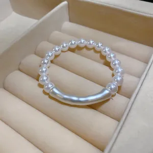 Bracelet élégant en perles blanches avec un ornement baroque irrégulier de couleur argent