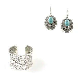 Detail of vintage bohemian silver alloy bracelet and turquoise earrings with floral motifs