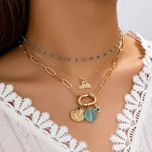 Three-layer gold necklace set with blue beads, cocktail letters, and sea shell charms