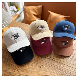 Détail de casquettes enfant multicolores avec broderie Shiba Inu sur tissu en coton