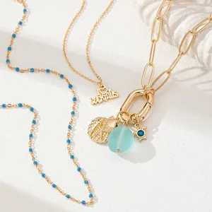 Golden multilayer necklace set with blue beads, cocktail heart pendant and seashell charms