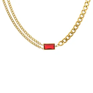 Gros plan du collier plaqué or avec cristal rouge et chaîne cubaine asymétrique