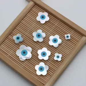 Detailansicht von blumenförmigen Muschelperlen mit dem blauen Evil-Eye-Motiv