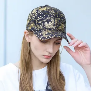 Close-up of black baseball cap with golden street graffiti prints and metal heart patterns