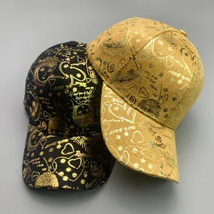Detailed view of black and gold baseball caps with metallic gold portrait and heart prints