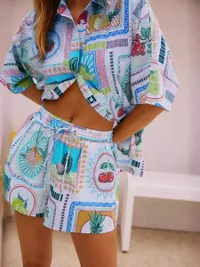 Detail of colorful fruit print on white cotton shirt and drawstring shorts summer set