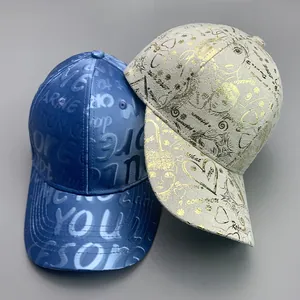 Detailed close-up of blue embossed satin and cream graffiti print cotton baseball caps