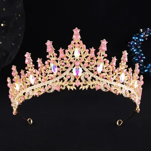 Detailed close-up of golden bridal crown with pink rhinestones and teardrop gems