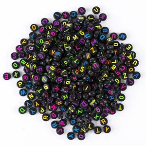 Close-up of black round acrylic alphabet beads with colorful letters for DIY jewelry