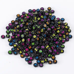 Close-up of assorted acrylic black beads with colorful A-Z letters for DIY jewelry making