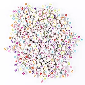 Macro detail of white round acrylic beads with colorful A-Z alphabet letters for DIY