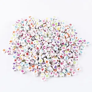 Macro detail of 6mm white acrylic cube beads with colorful A-Z alphabet letters for DIY