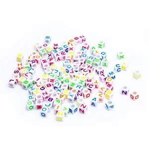 Macro shot of white acrylic cube alphabet beads with colorful A-Z letters for jewelry DIY