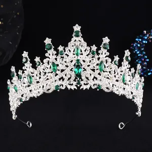 Close-up of silver bridal crown featuring green gemstones and sparkling white rhinestones