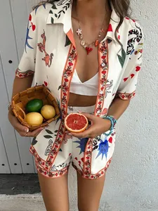 Detail shot of summer two-piece set featuring colorful artistic prints and orange piping