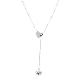 Minimalist silver heart lariat necklace with polished double pendants on white background