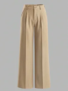 Detail of high waisted wide leg trousers featuring vertical stripes and a button closure