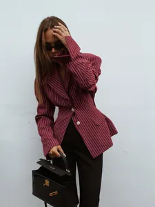 Detail of burgundy striped blazer with white buttons and a classic leather handbag