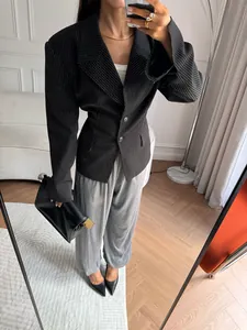 Detail of a slim-fit black striped blazer paired with grey wide-leg trousers for office wear