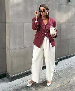 Detail of burgundy pinstripe blazer paired with elegant wide-leg trousers for chic women