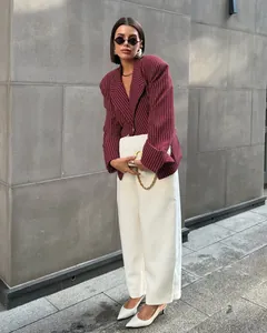 Detail of burgundy striped slim-fit blazer paired with white high-waist wide-leg pants