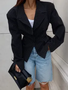 Macro detail of structured padded shoulders and pinstripe texture on a black blazer