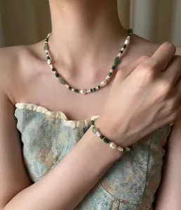 Close-up of pearl and green agate beaded necklace on model showing elegant craftsmanship