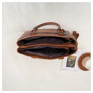 Top view of caramel brown handbag featuring dual zipper compartments and tassel detail