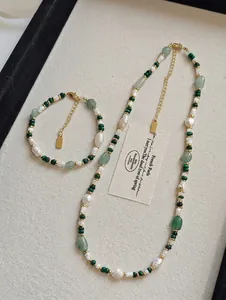 Detail of freshwater pearl necklace set with green aventurine stones and gold accents