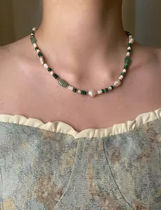 Close-up of green aventurine and freshwater pearl necklace with gold metal beads