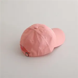 Détail de la casquette de baseball en coton rose avec boucle en métal et broderie