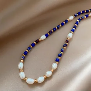 Close-up of freshwater pearls and blue lapis lazuli beads on beige silk fabric