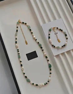 Detail of freshwater pearl necklace with green aventurine beads and golden lobster clasp