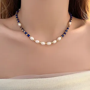 Close-up of freshwater pearls and blue lapis lazuli beads on a gold necklace