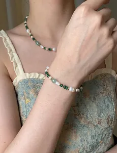 Detailed view of model wearing green agate and freshwater pearl beaded necklace set