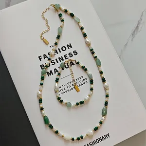 Detail of green aventurine and freshwater pearl necklace set on fashion book background