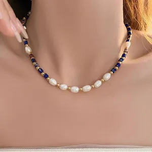 Close-up of freshwater pearl and lapis lazuli beaded necklace worn by a model